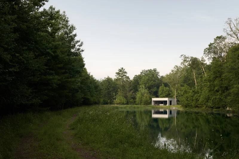 David Gensler outdoor style reference showing a minimalist Vipp cabin reflected in a quiet forest lake.